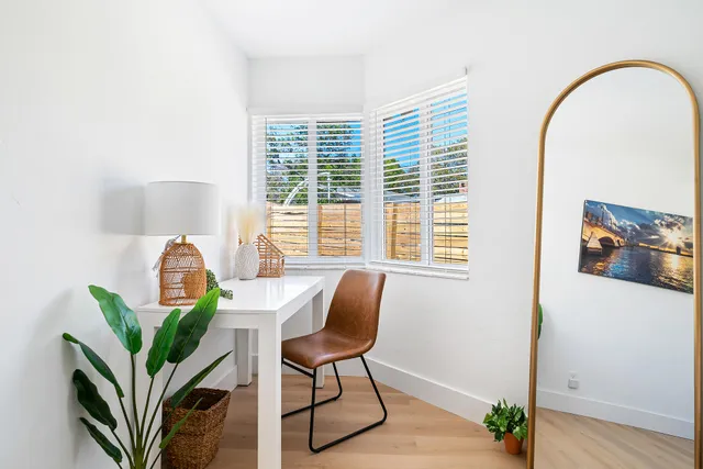 a view of a workspace with furniture and a window