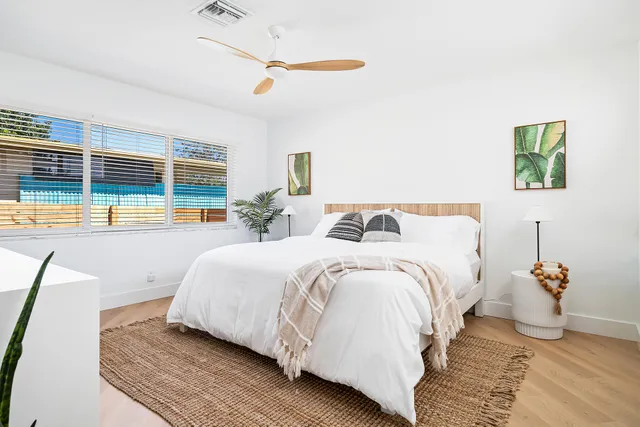 a bedroom with a bed and a large window