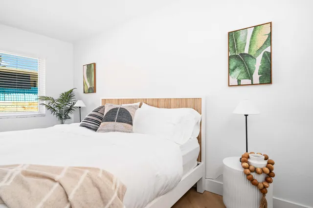 a bedroom with a bed and painting on the wall