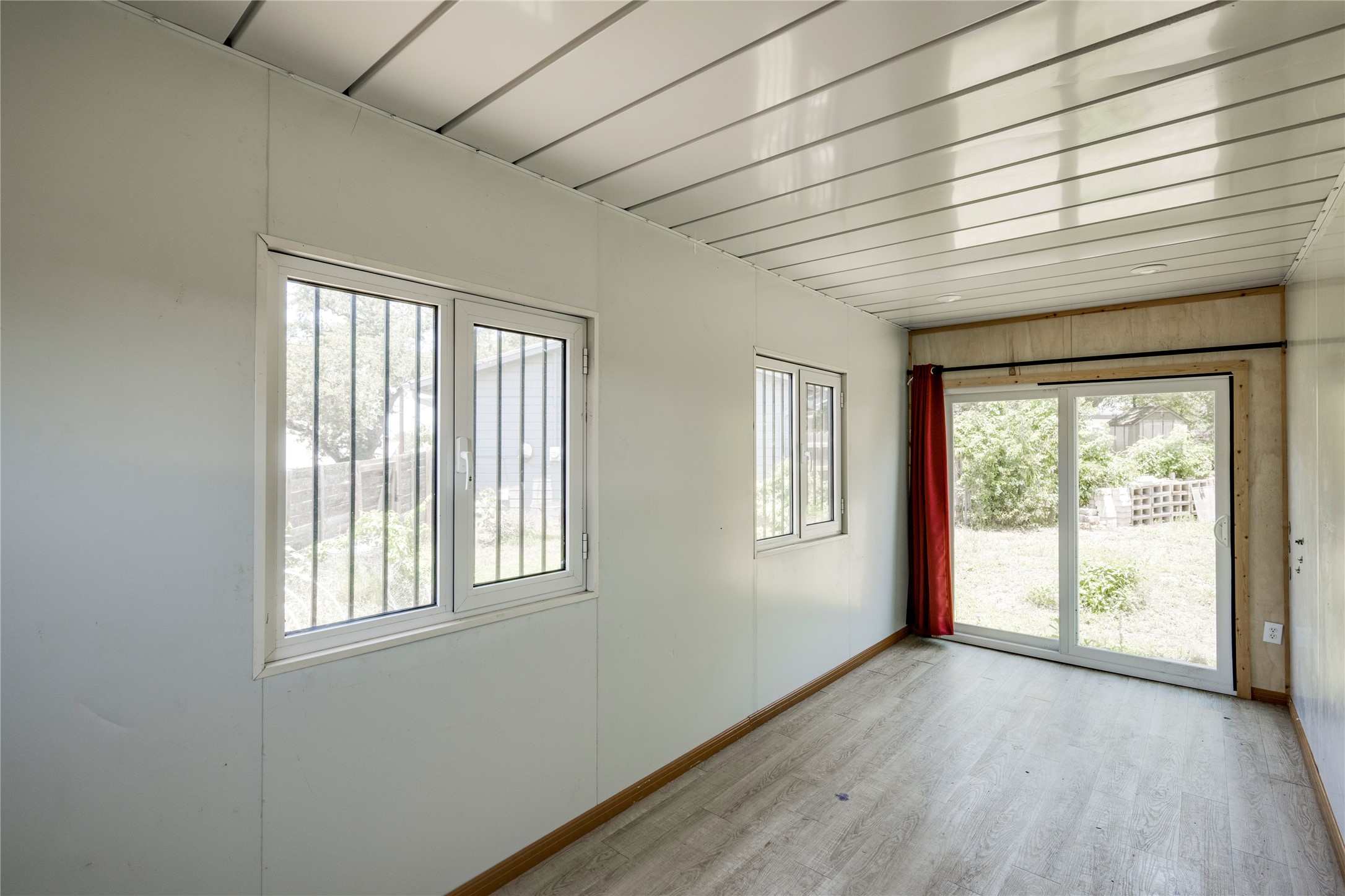 1707 Overhill Drive Austin, TX 78721 - Photo 21 of 36 A versatile interior space featuring modern flooring and ample natural light from multiple windows and a sliding glass door.