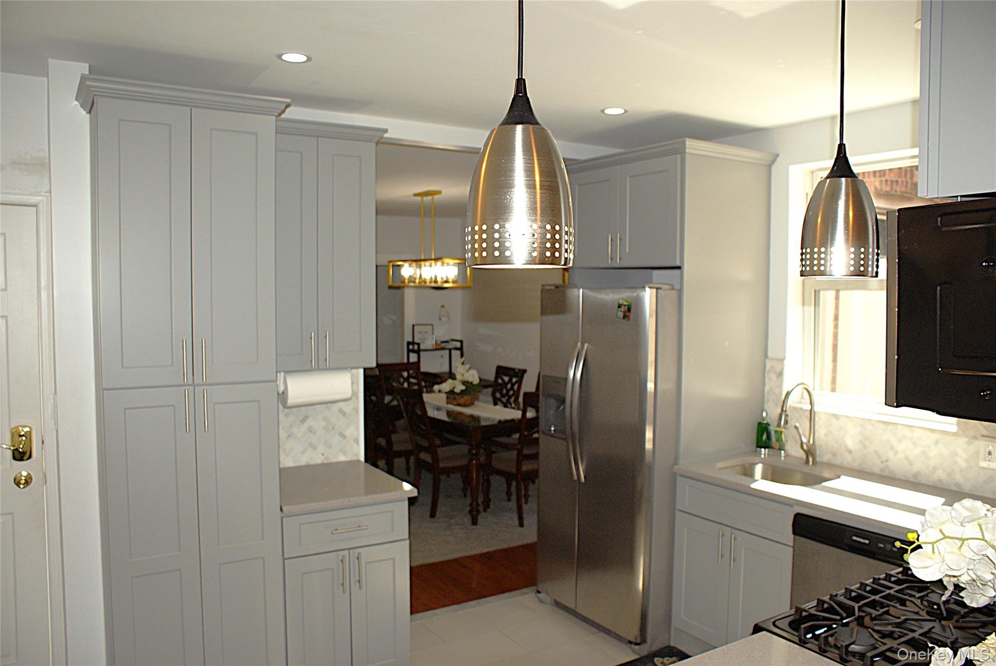 600 Flatbush Avenue Brooklyn, NY 11225 - Photo 10 of 17 Kitchen with decorative backsplash, appliances with stainless steel finishes, hanging light fixtures, light stone counters, and recessed lighting