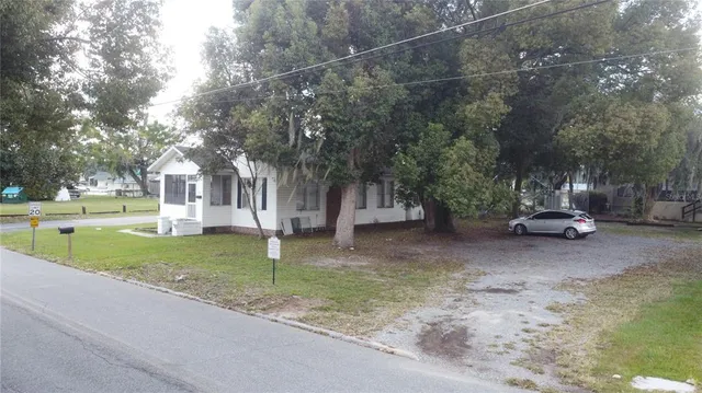 a view of a house with a yard and tree s