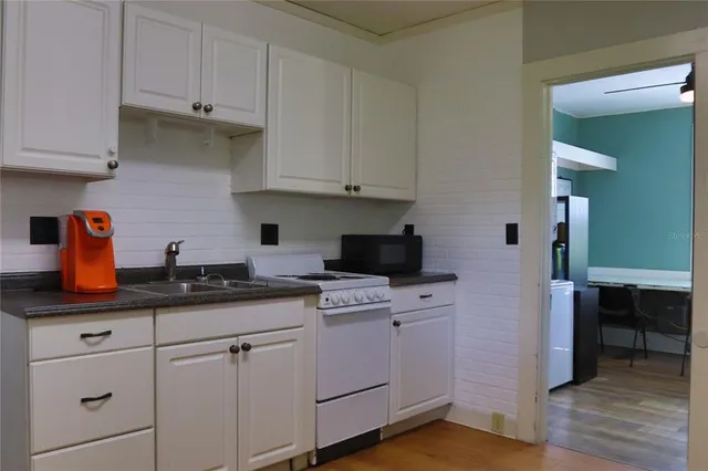 a kitchen with cabinets appliances a sink and a counter space