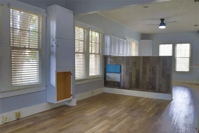 a view of a kitchen with a fridge and wooden floor