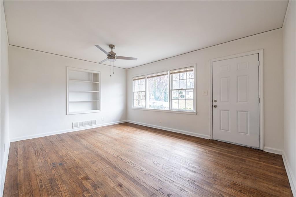 2986 Belvedere Lane Decatur, GA 30032 - Photo 3 of 18 an empty room with wooden floor chandelier fan and windows