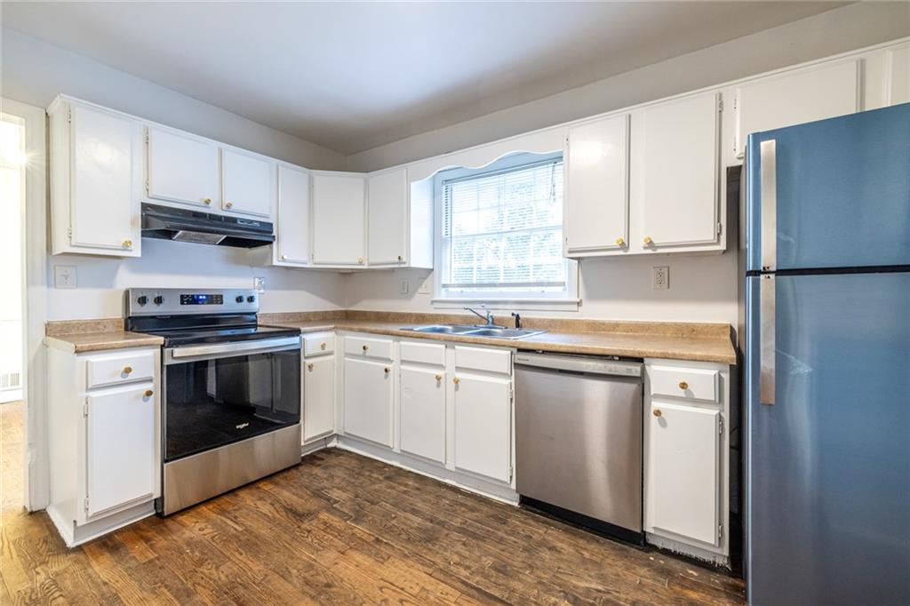 2986 Belvedere Lane Decatur, GA 30032 - Photo 6 of 18 a kitchen with granite countertop white cabinets and white appliances