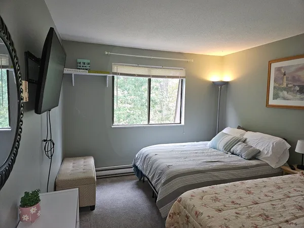 a bedroom with a bed and a painting on the wall