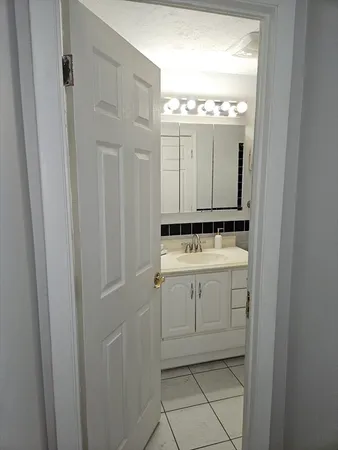 a bathroom with a granite countertop sink toilet and mirror