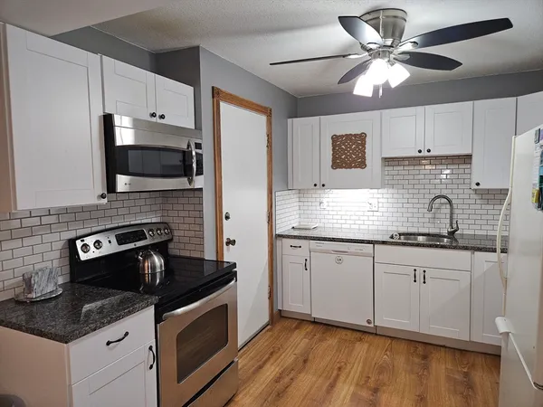 a kitchen with granite countertop a sink stainless steel appliances and cabinets