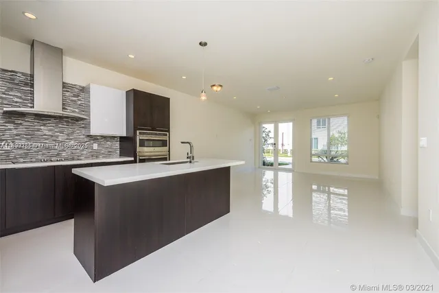 a kitchen with stainless steel appliances kitchen island granite countertop a refrigerator a sink and a stove