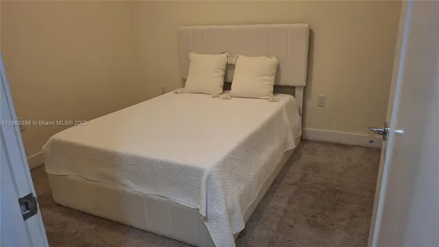 a bed sitting in a bedroom next to a bathroom