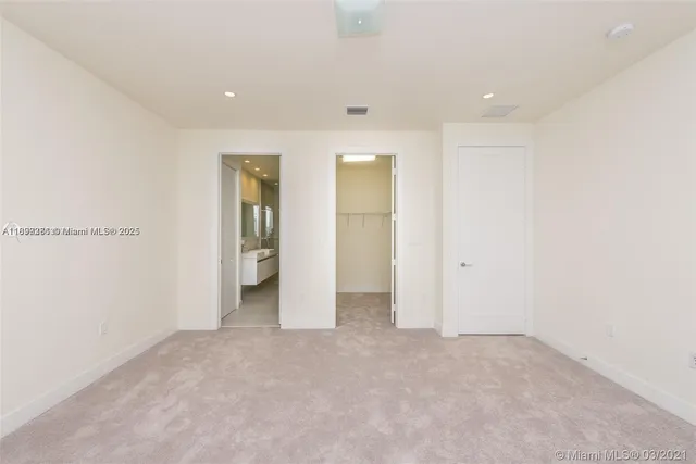 an empty room with closet and wooden door