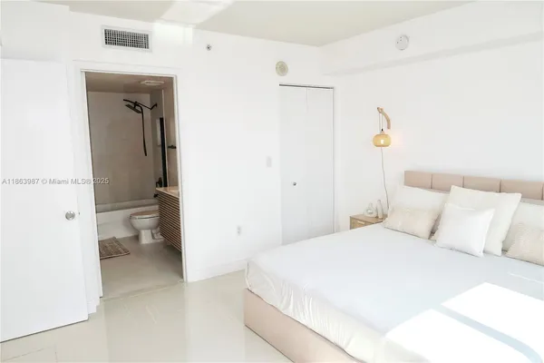 a bedroom with a bed and a view of bathroom