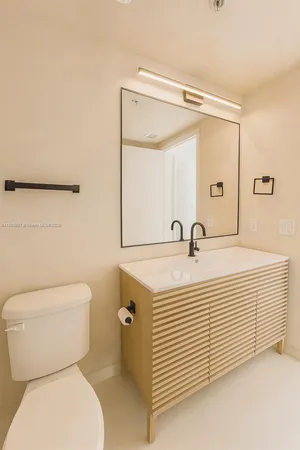 a bathroom with a sink a toilet and a mirror