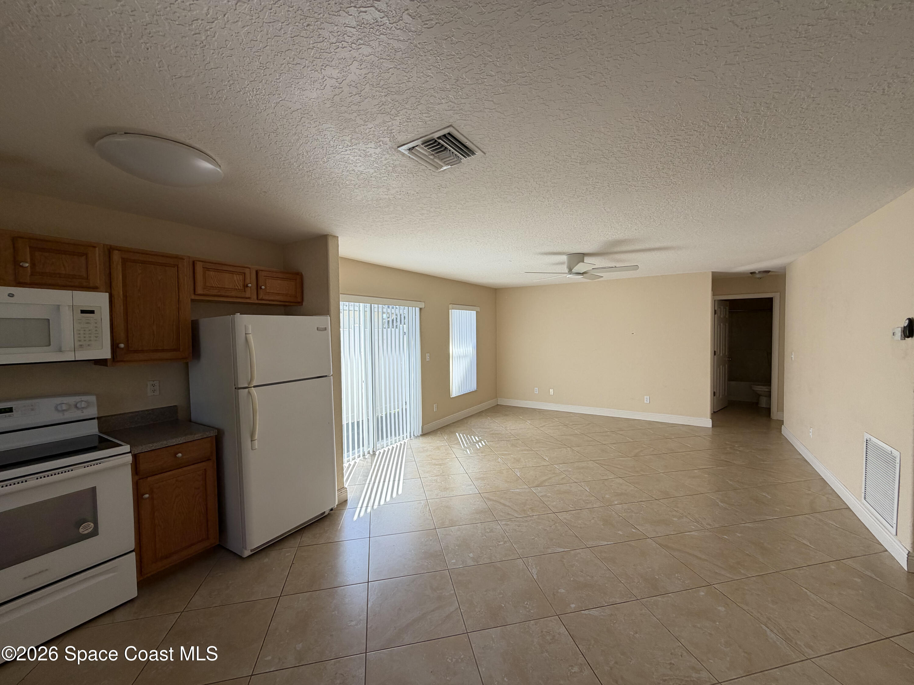 1904 Fletcher Street Melbourne, FL 32901 - Photo 3 of 23 a view of a kitchen with refrigerator and microwave