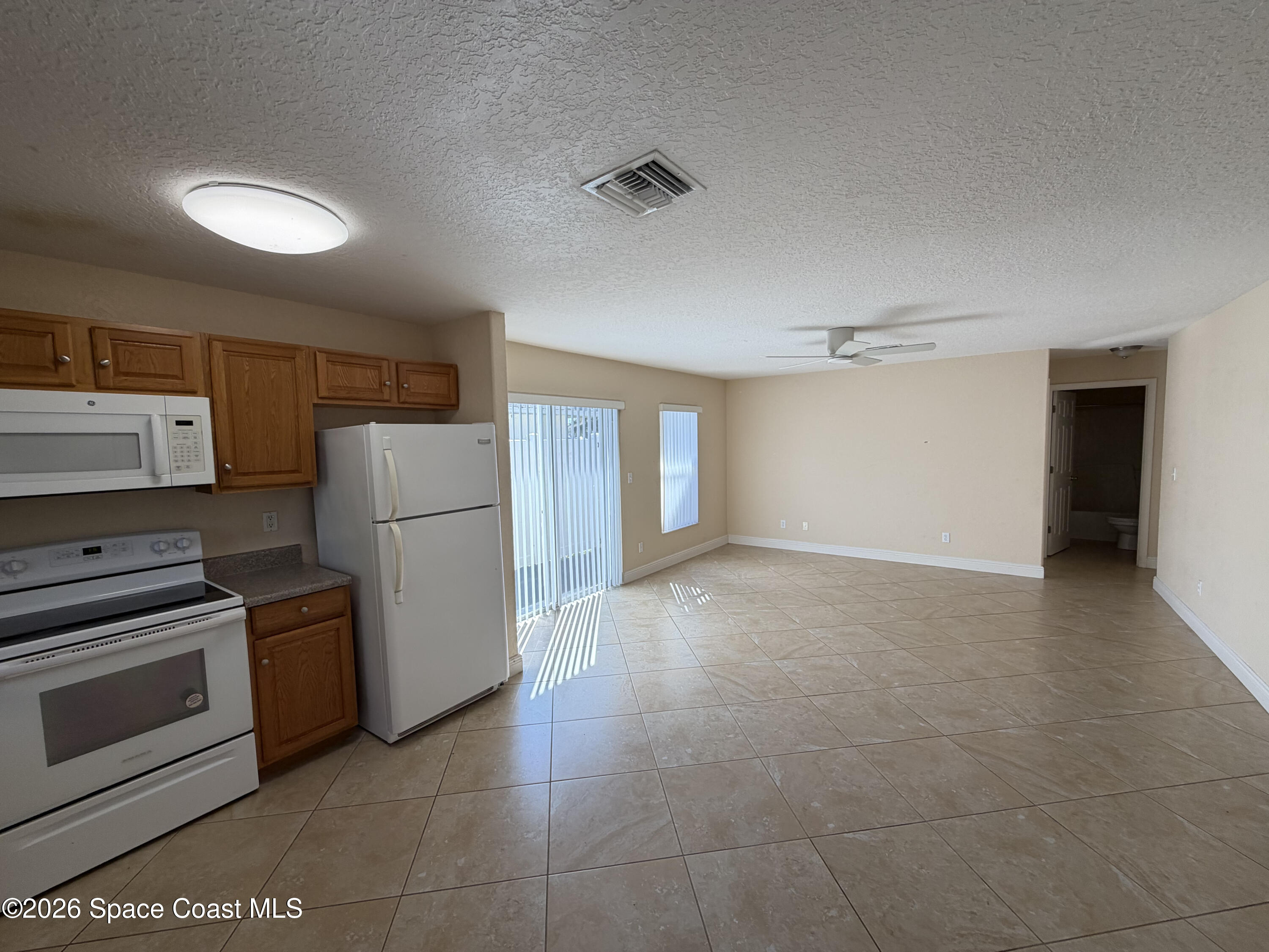 1904 Fletcher Street Melbourne, FL 32901 - Photo 4 of 23 a view of a kitchen with a stove cabinets and a refrigerator