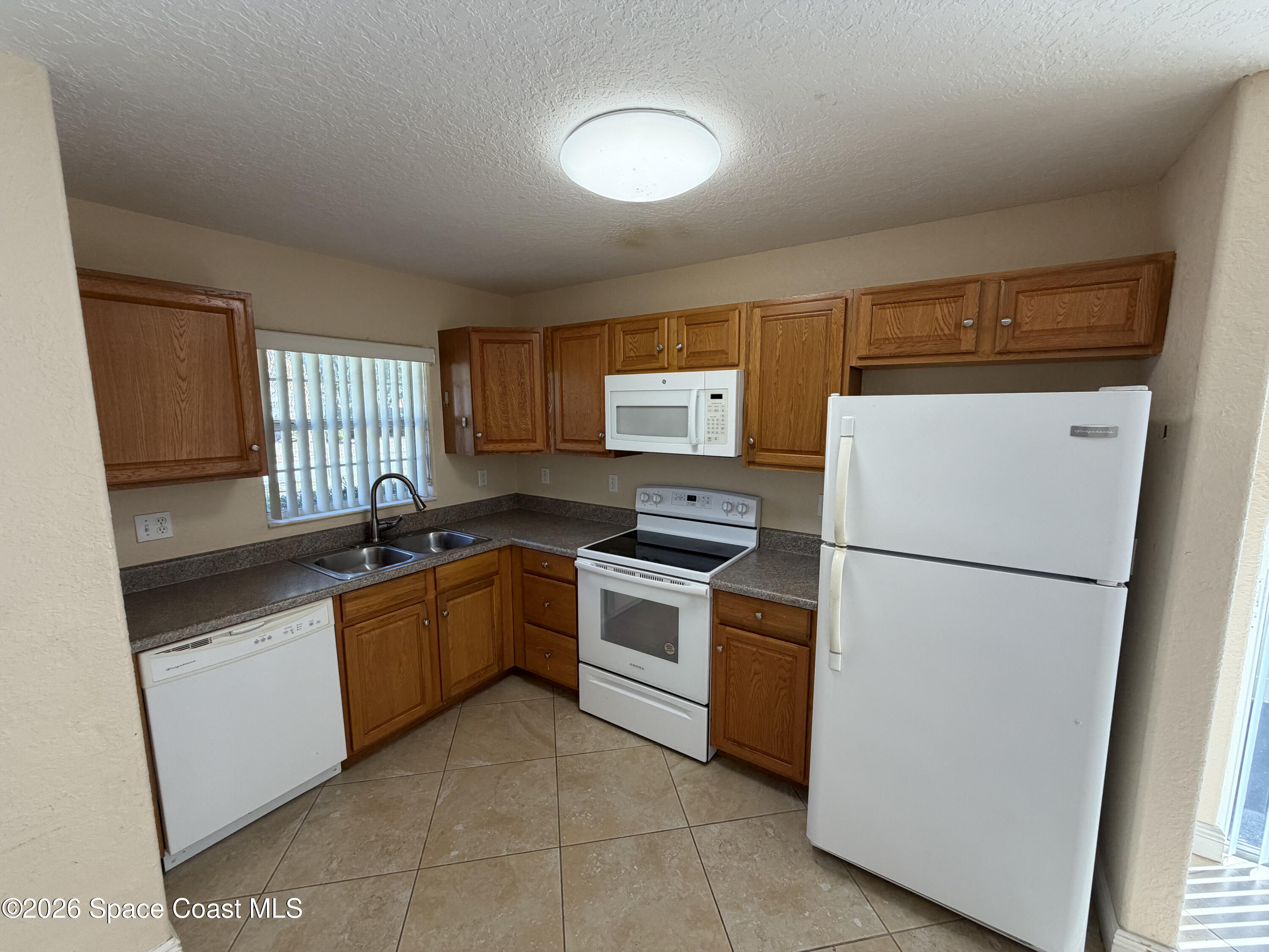 1904 Fletcher Street Melbourne, FL 32901 - Photo 6 of 23 a kitchen with a sink a refrigerator and cabinets