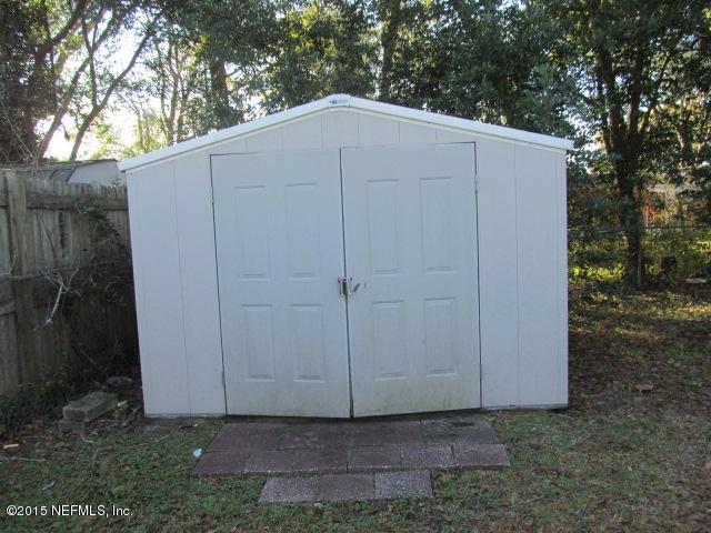 7658 Rambler Road Jacksonville, FL 32244 - Photo 11 of 13 a backyard of a house with a small barn and wooden fence