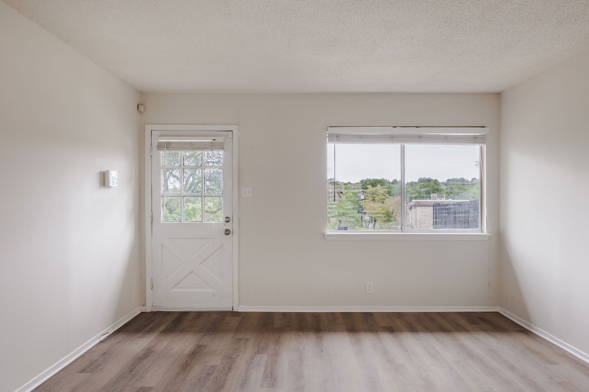 2012 Cody Court Austin, TX 78704 - Photo 25 of 40 Natural light fills this room, showcasing the durable wood flooring and scenic outdoor views.