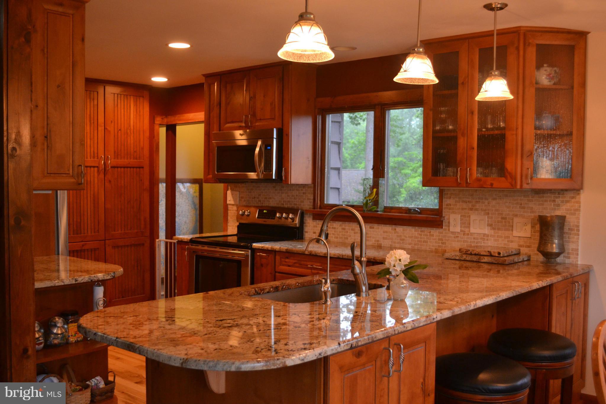 4012 Elder Road Port Republic, MD 20676 - Photo 9 of 25 a kitchen with stainless steel appliances granite countertop a sink a stove and a wooden cabinets