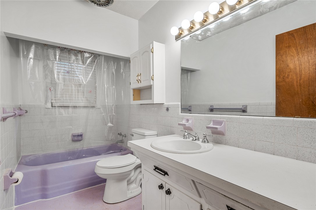 2101 Old Spring Drive Anderson, SC 29625 - Photo 18 of 36 A well-lit bathroom features a spacious vanity with a large mirror, complemented by a purple bathtub and coordinating flooring.