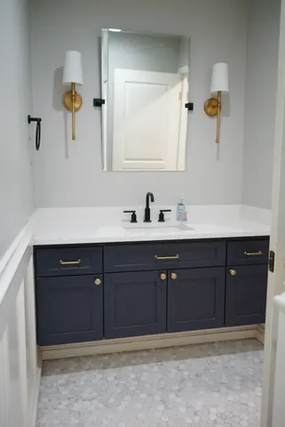 a bathroom with a sink vanity and mirror