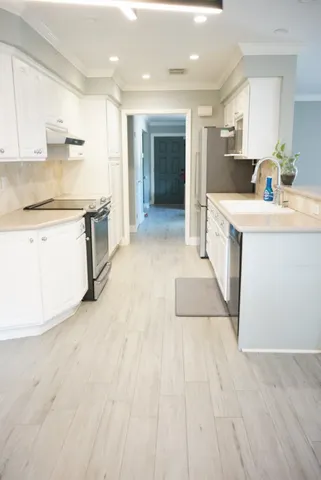 a view of a kitchen with sink a stove and a refrigerator