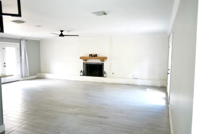 a view of empty room with wooden floor