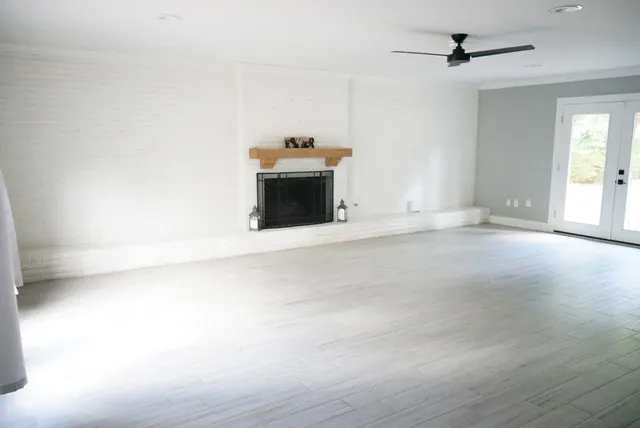 a view of an empty room with a fireplace and a window