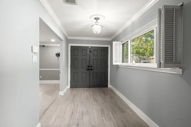 a view of hallway with a large window and wooden floor