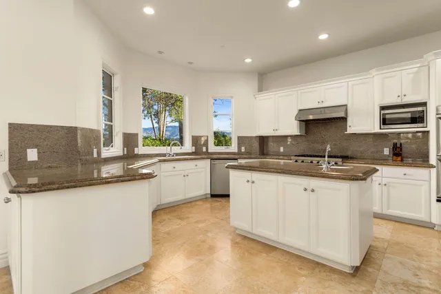 a kitchen with stainless steel appliances granite countertop a sink and cabinets