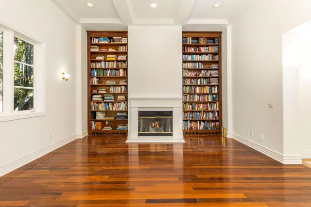 a view of an empty room with window and fire place