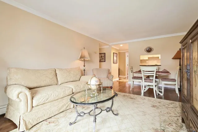 a living room with furniture a dining table and chairs with wooden floor