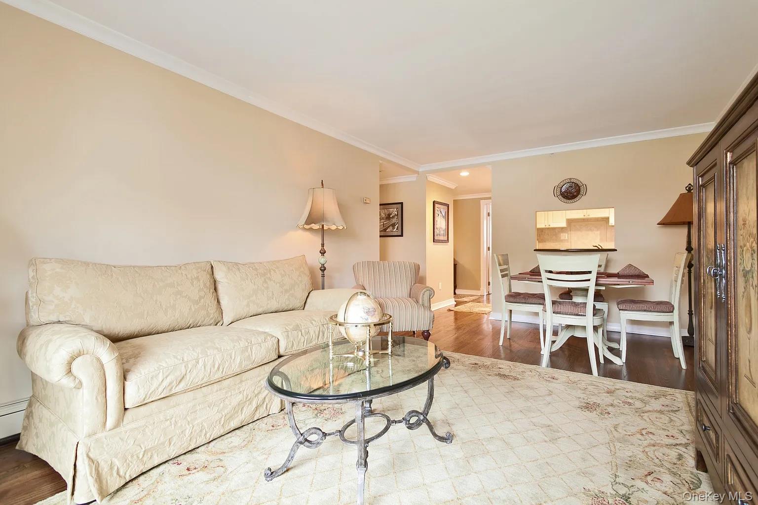 a living room with furniture a dining table and chairs with wooden floor
