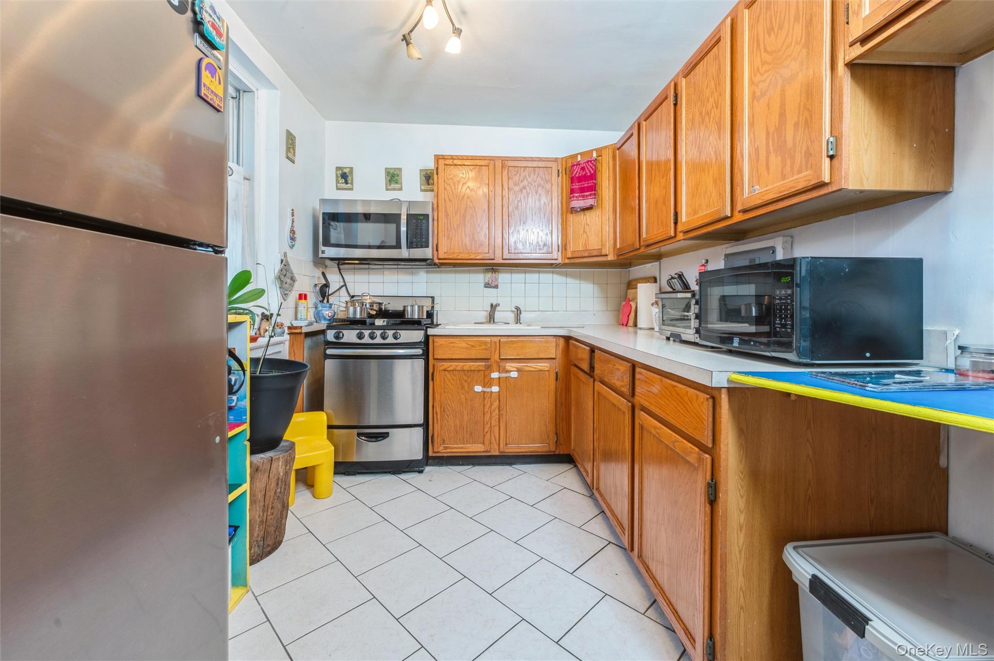 755 Bronx River Road, Unit 1C Bronxville, NY 10708 - Photo 2 of 16 a kitchen with stainless steel appliances a stove a sink and a microwave