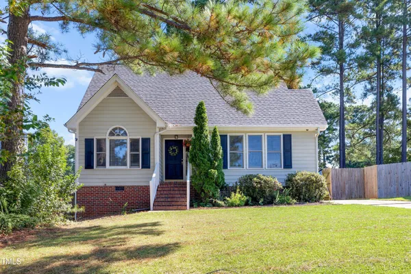 a front view of a house with a garden and yard