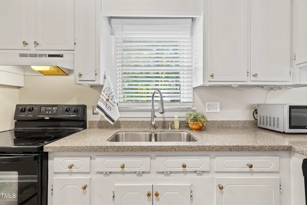 a kitchen with appliances cabinets and a window