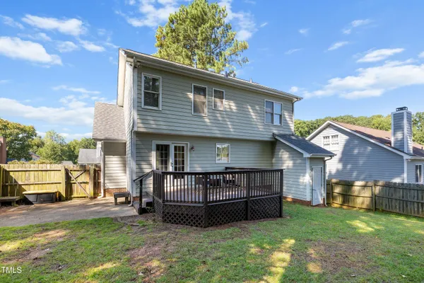 a view of backyard with green space and wooden fence
