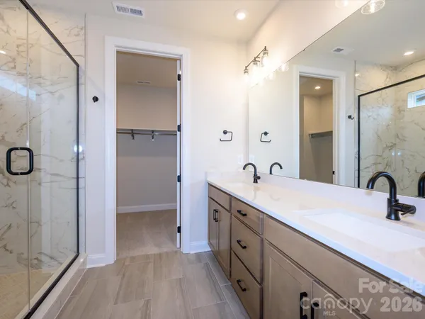 a bathroom with a double vanity sink a mirror and shower