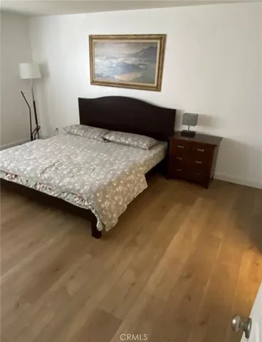 a bedroom with a bed a mirror and windows