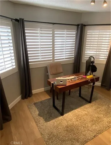 a view of a workspace with furniture and a window