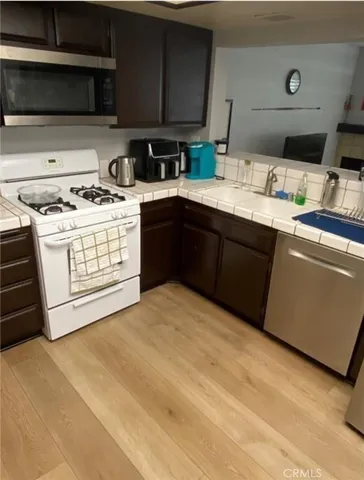 a kitchen with stainless steel appliances a stove microwave and cabinets