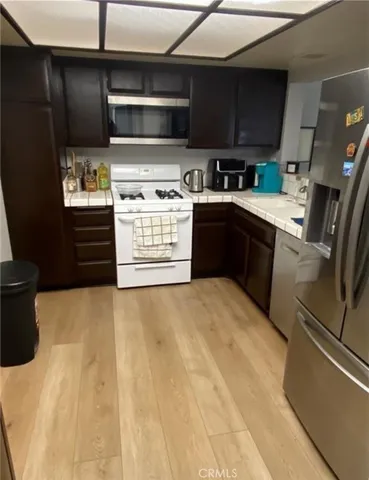 a kitchen with stainless steel appliances kitchen island granite countertop a stove top oven a sink and dishwasher