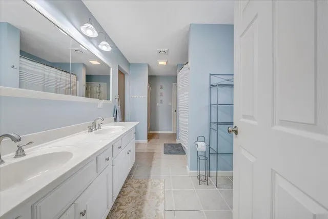 a spacious bathroom with a double vanity sink and mirror