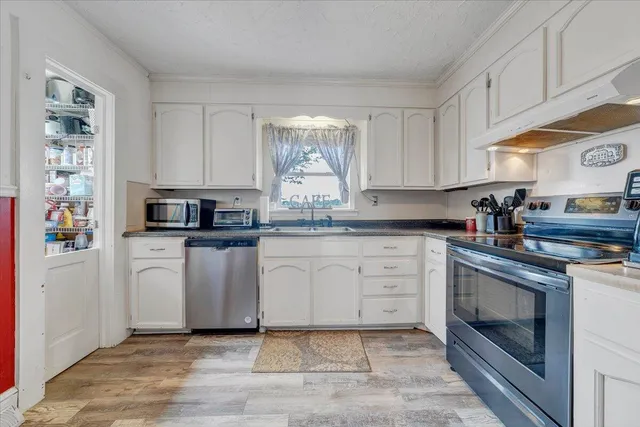 a kitchen with white cabinets stainless steel appliances and sink
