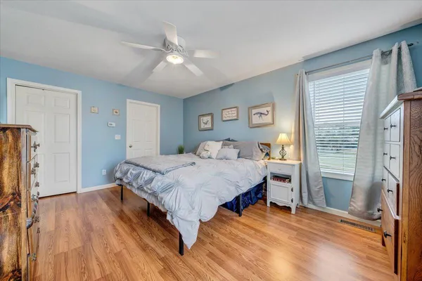 a spacious bedroom with a bed and a flat screen tv