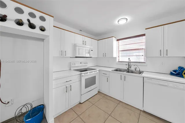 a kitchen with white cabinets and white appliances