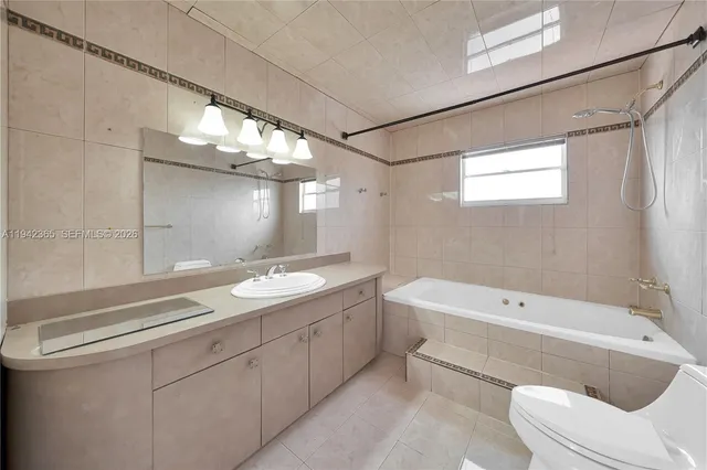 a bathroom with a tub sink and mirror