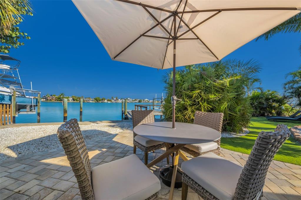 16101 Redington Drive Redington Beach, FL 33708 - Photo 14 of 43 a view of a patio with table and chairs under an umbrella