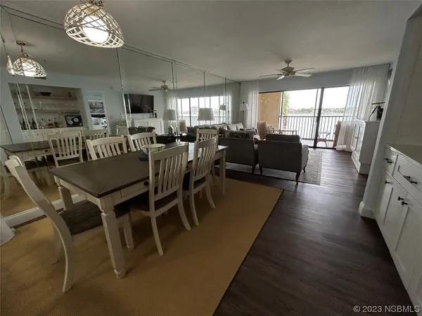 a view of a dining room with furniture a chandelier and wooden floor